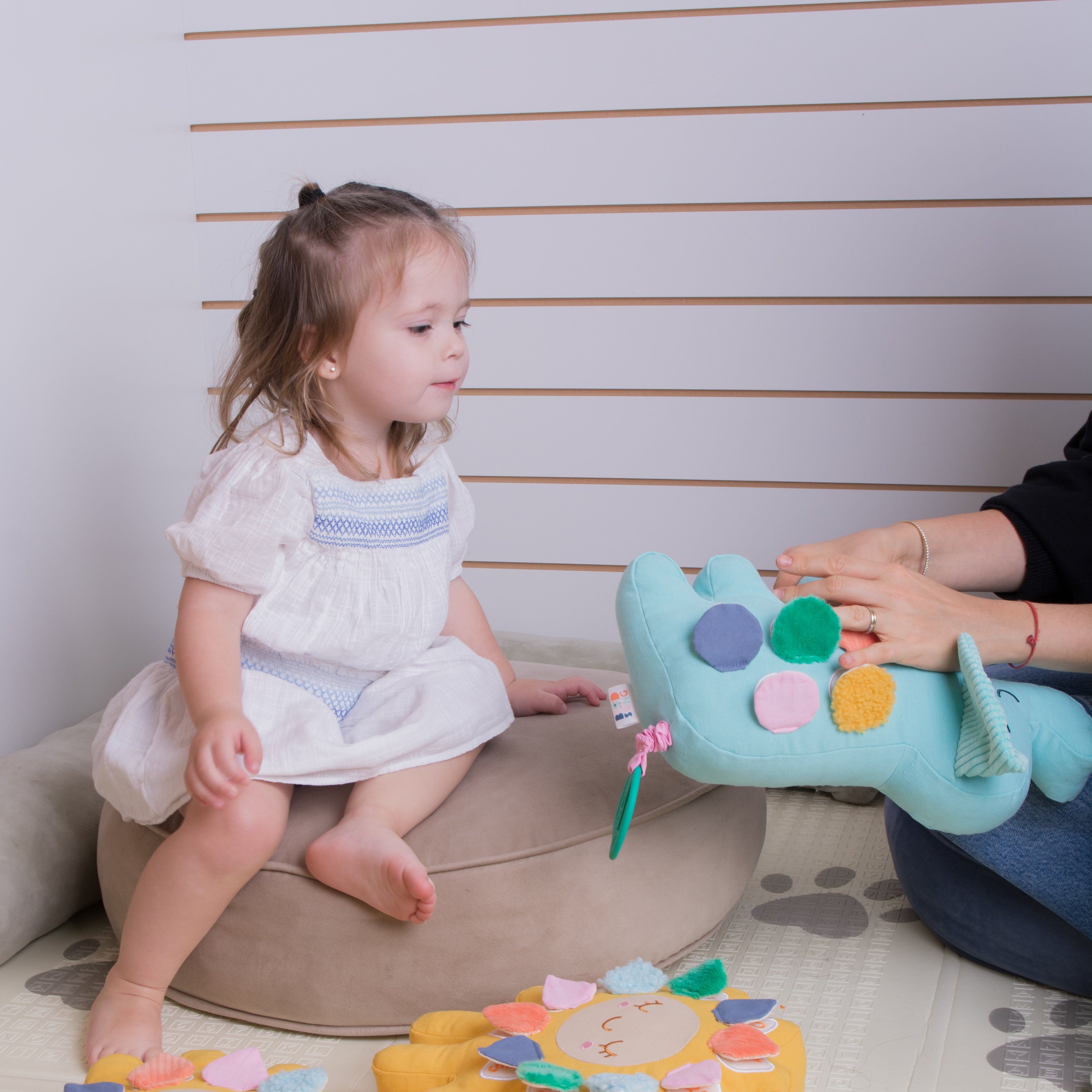 A toddler girl is playing with her mom and Birdsong's bilingual elephant toy