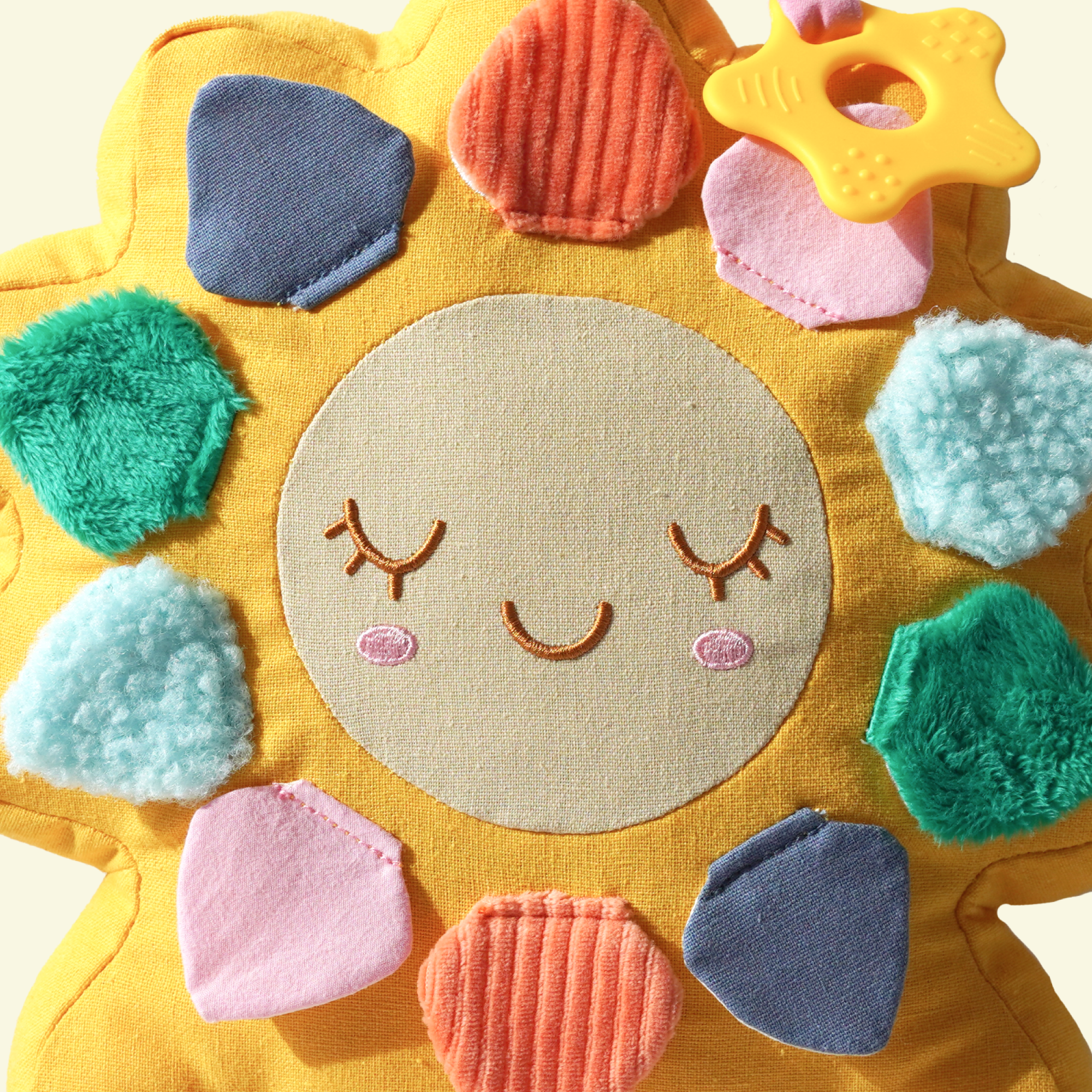 Colorful sun-shaped toy with a smiling face on a light background